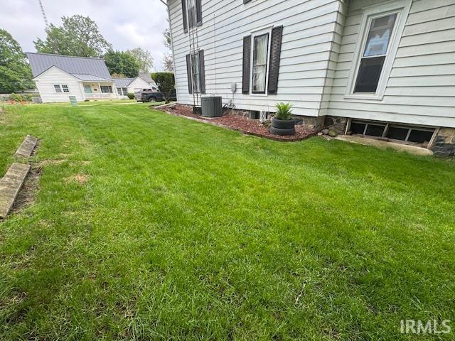 view of green lawn featuring central air condition unit