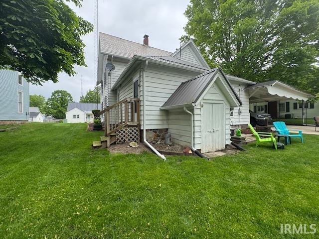 back of property with a yard and a chimney