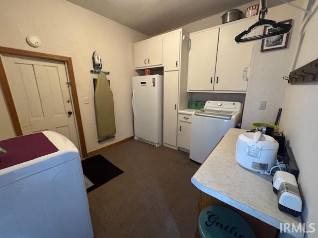 clothes washing area featuring cabinet space, carpet flooring, and washing machine and clothes dryer