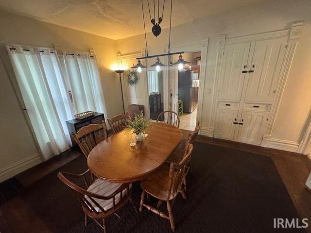 dining room featuring baseboards and dark wood-style flooring