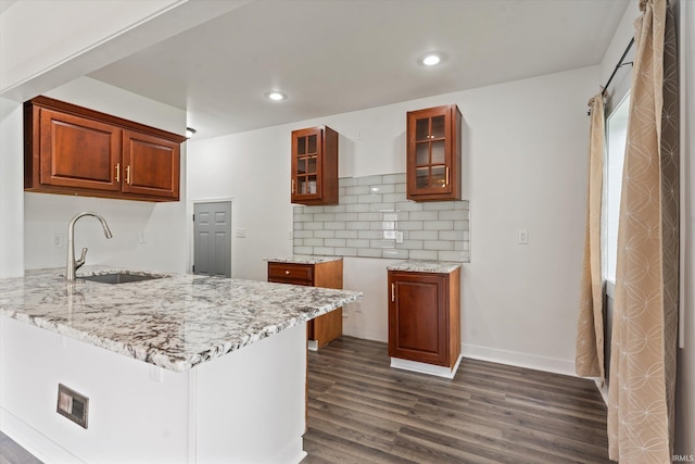 kitchen featuring a sink, light stone countertops, dark wood-style flooring, and recessed lighting