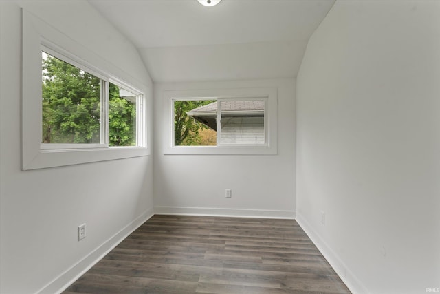 unfurnished room with vaulted ceiling, dark wood-type flooring, and baseboards