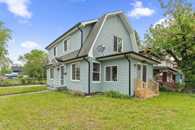 view of side of home featuring a gambrel roof and a shingled roof