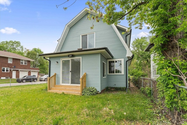 rear view of property featuring a gambrel roof and entry steps