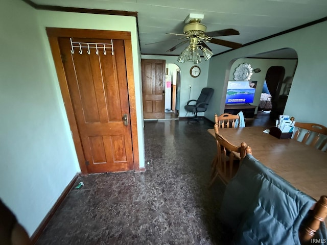 dining room featuring arched walkways, ceiling fan, and baseboards