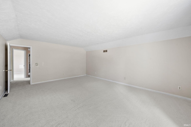 50880 Cherry Farm Trl, Granger, IN 46530 - additional living space featuring vaulted ceiling, light carpet, baseboards, and a textured ceiling