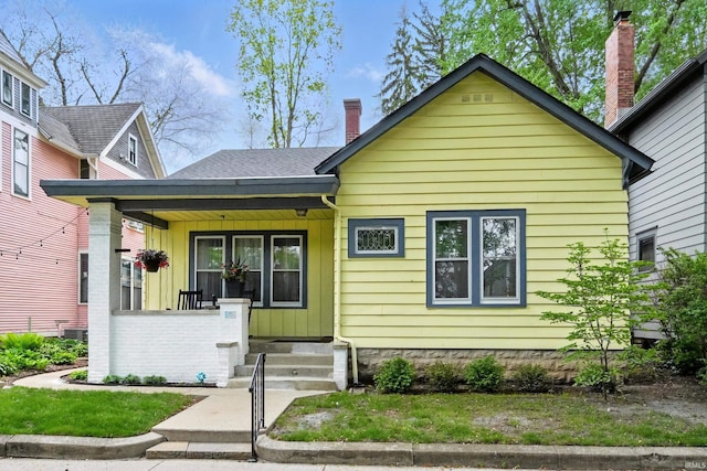 1021 W Wayne St, Fort Wayne, IN 46802 - bungalow-style house featuring a porch, board and batten siding, and a chimney