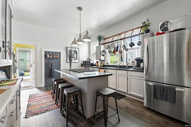 1021 W Wayne St, Fort Wayne, IN 46802 - kitchen featuring appliances with stainless steel finishes, dark wood-style flooring, a breakfast bar, and a kitchen island