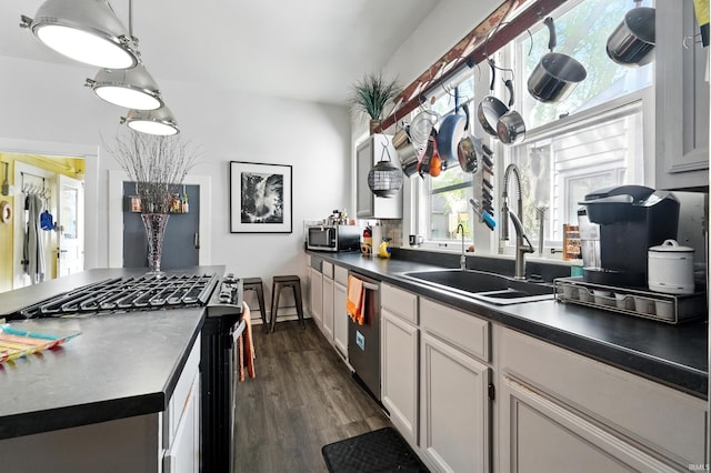 1021 W Wayne St, Fort Wayne, IN 46802 - kitchen with appliances with stainless steel finishes, a sink, dark wood-type flooring, white cabinetry, and dark countertops