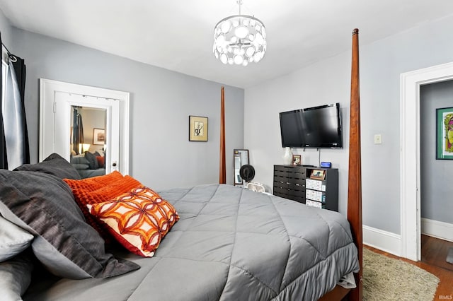 1021 W Wayne St, Fort Wayne, IN 46802 - bedroom with wood finished floors, baseboards, and a chandelier