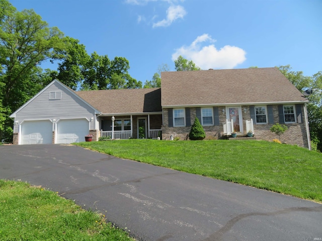 1243 Bellgrade Ave, Loogootee, IN 47553 - view of front of property with brick siding, an attached garage, asphalt driveway, a front lawn, and covered porch