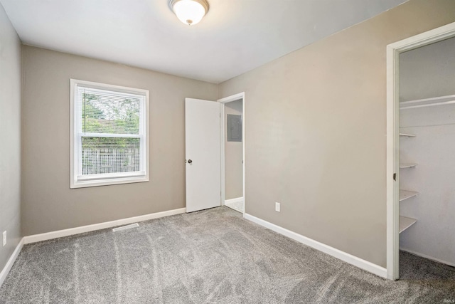 1317 W Tate St, Kokomo, IN 46901 - unfurnished bedroom featuring carpet floors, a spacious closet, and baseboards