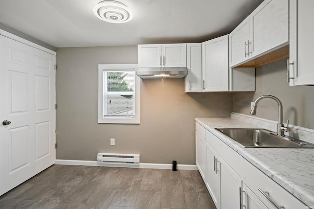 1317 W Tate St, Kokomo, IN 46901 - kitchen with a sink, baseboard heating, white cabinetry, light countertops, and baseboards