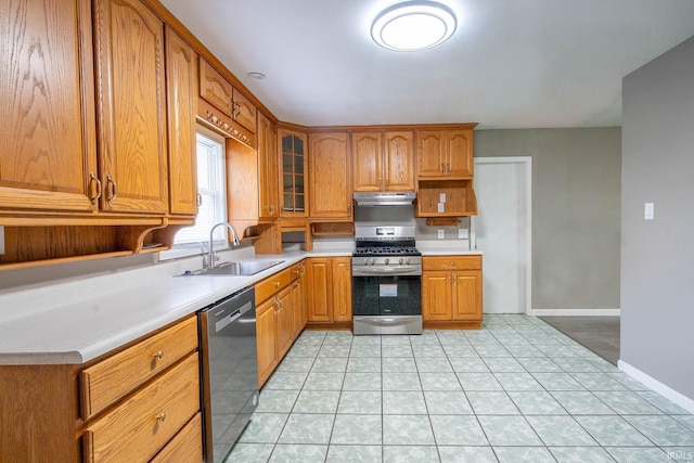 1317 W Tate St, Kokomo, IN 46901 - kitchen with stainless steel appliances, a sink, under cabinet range hood, light countertops, and brown cabinets