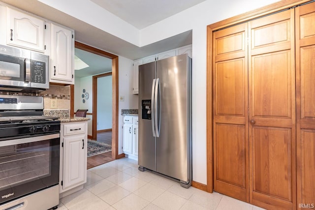 kitchen featuring stainless steel appliances, baseboards, light stone countertops, tasteful backsplash, and white cabinets