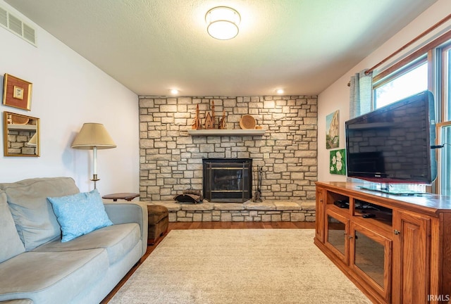 living room with a fireplace, wood finished floors, and a textured ceiling