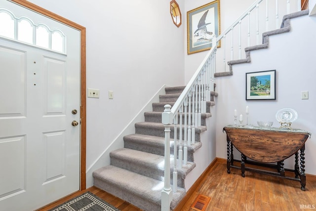 entrance foyer with stairs and wood finished floors