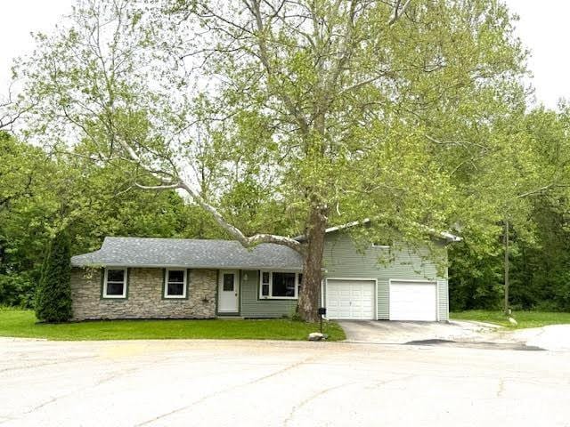 view of front of property with concrete driveway and stone siding