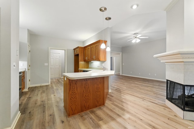 12908 Chaplin Ct, Fort Wayne, IN 46845 - kitchen with ceiling fan, light countertops, a sink, brown cabinets, and a tiled fireplace