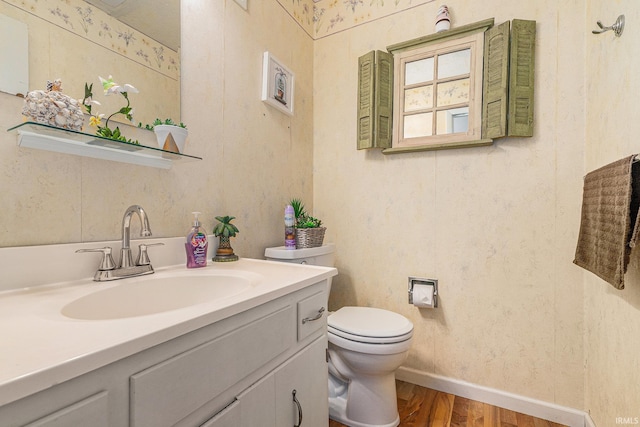 56635 N Wedgewood Ave, Elkhart, IN 46516 - bathroom with wood finished floors, toilet, vanity, and baseboards