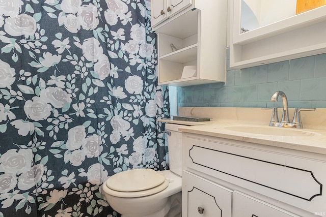 bathroom with backsplash, vanity, and toilet