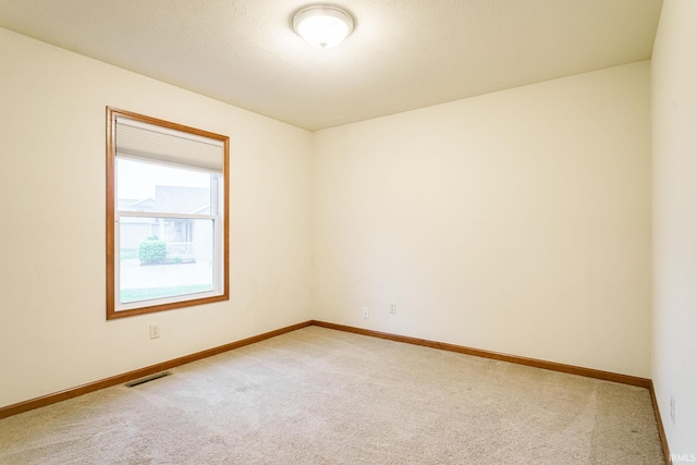 empty room featuring carpet floors and baseboards