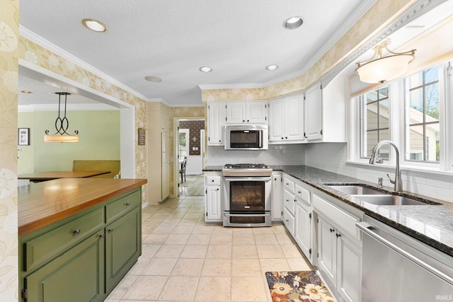 14612 Liberty Mills Rd, Fort Wayne, IN 46814 - kitchen with stainless steel appliances, green cabinetry, wallpapered walls, a sink, and white cabinetry