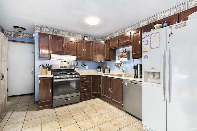 1612 W Grant St, Bremen, IN 46506 - kitchen featuring stainless steel appliances, under cabinet range hood, a sink, light countertops, and light tile patterned floors