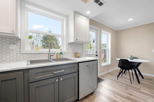 kitchen featuring stainless steel dishwasher, a sink, gray cabinets, ornamental molding, and light wood-style flooring