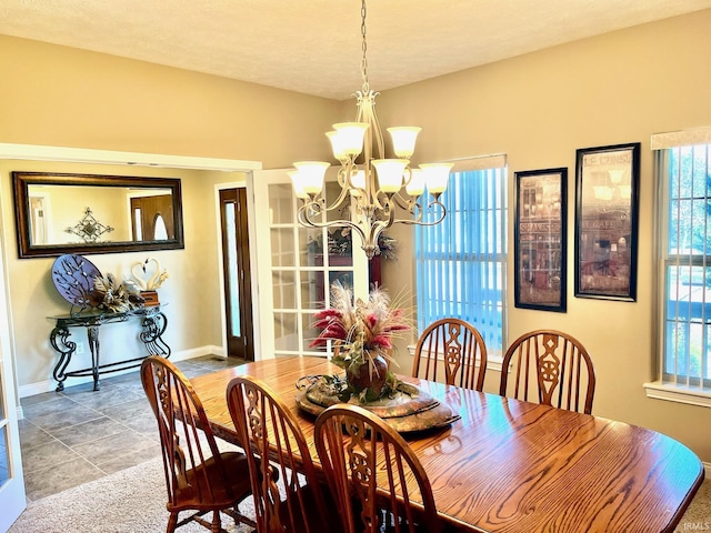 dining space with a chandelier, baseboards, and healthy amount of natural light