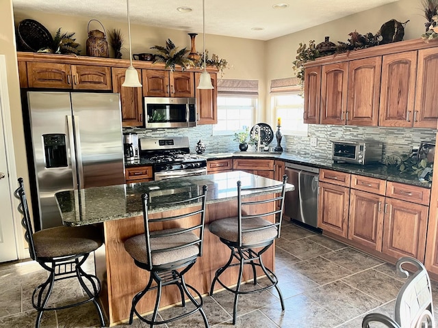 kitchen with stainless steel appliances, a sink, decorative backsplash, a center island, and recessed lighting