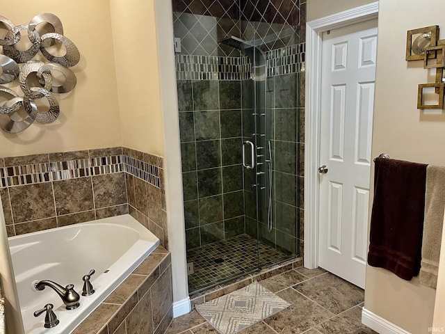 full bath featuring a stall shower, a chandelier, a bath, and tile patterned floors