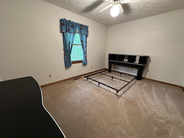 bedroom featuring a textured ceiling, carpet floors, baseboards, and ceiling fan