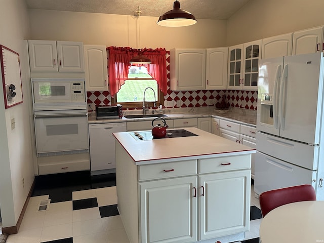 kitchen with white appliances, a sink, white cabinetry, and backsplash
