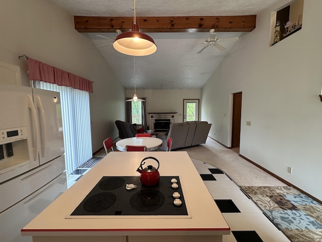kitchen with white fridge with ice dispenser, black electric stovetop, beamed ceiling, a fireplace, and light countertops