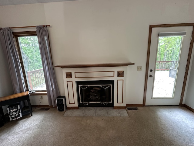 unfurnished living room featuring light colored carpet, baseboards, and a fireplace with flush hearth