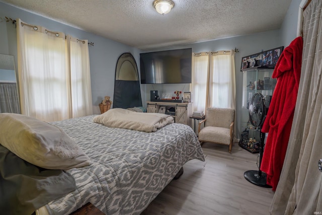 bedroom with a textured ceiling and wood finished floors