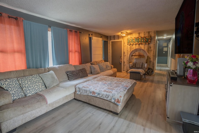 living room with a textured ceiling, light wood-style flooring, and wooden walls