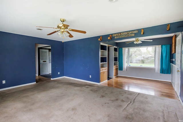carpeted spare room featuring a ceiling fan and baseboards