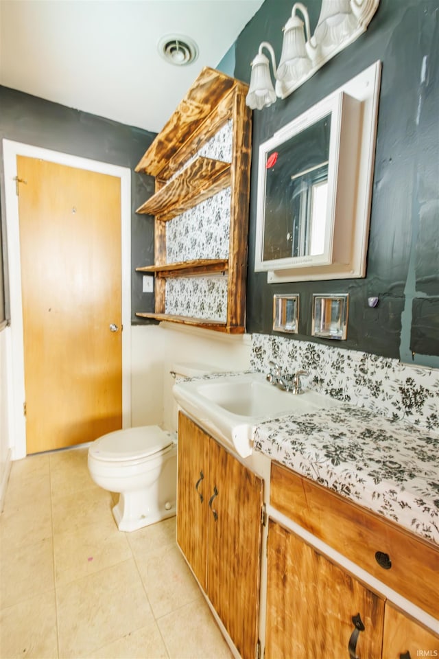 bathroom featuring tile patterned flooring, toilet, and vanity