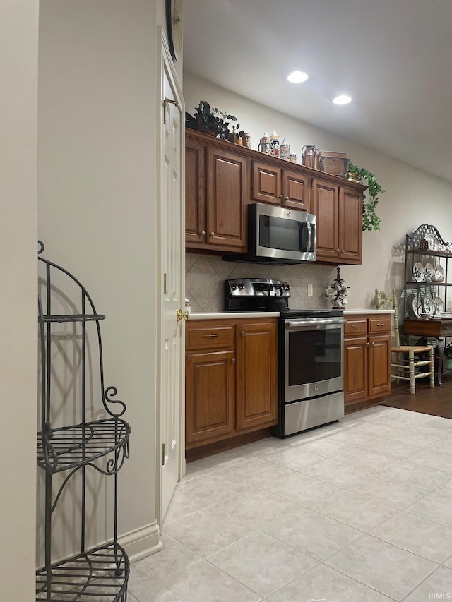 12116 Autumn Breeze Dr, Fort Wayne, IN 46845 - kitchen with stainless steel appliances, backsplash, light tile patterned flooring, recessed lighting, and brown cabinetry