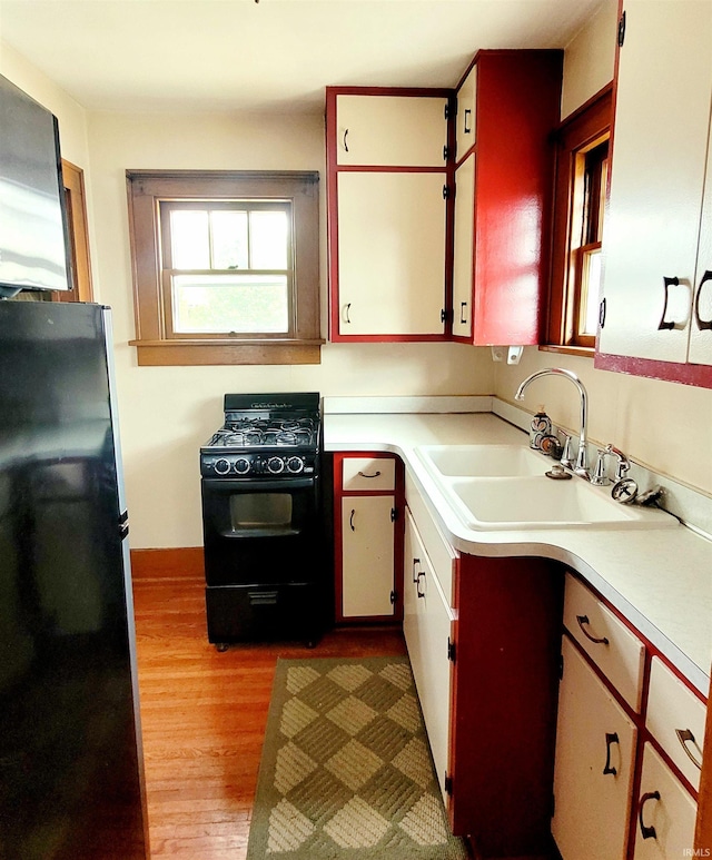 625 S 29th St, Lafayette, IN 47904 - kitchen featuring black appliances, a sink, light countertops, and wood finished floors