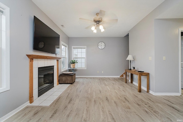 2507 Audri Ln, Kokomo, IN 46901 - unfurnished living room featuring wood finished floors, ceiling fan, a tiled fireplace, and baseboards