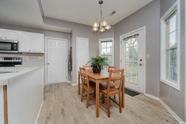 2507 Audri Ln, Kokomo, IN 46901 - dining space with light wood-style floors, a chandelier, and baseboards