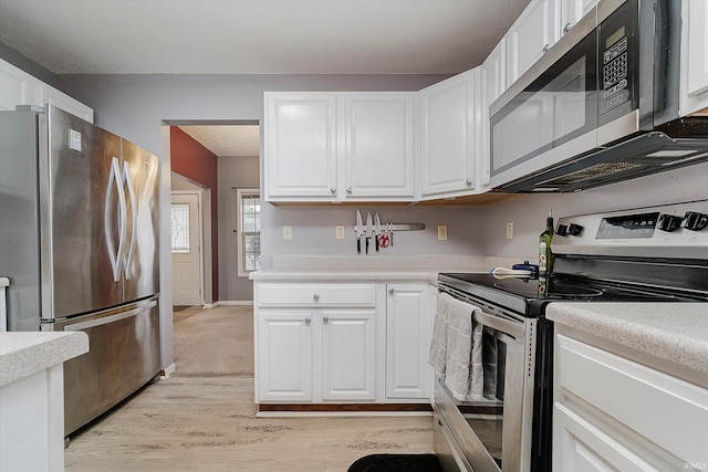 2507 Audri Ln, Kokomo, IN 46901 - kitchen with stainless steel appliances, light wood-style floors, light countertops, and white cabinetry