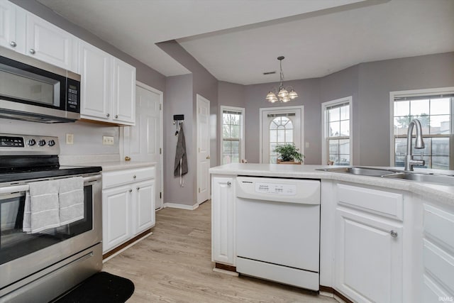 2507 Audri Ln, Kokomo, IN 46901 - kitchen with stainless steel appliances, a sink, a chandelier, and white cabinets