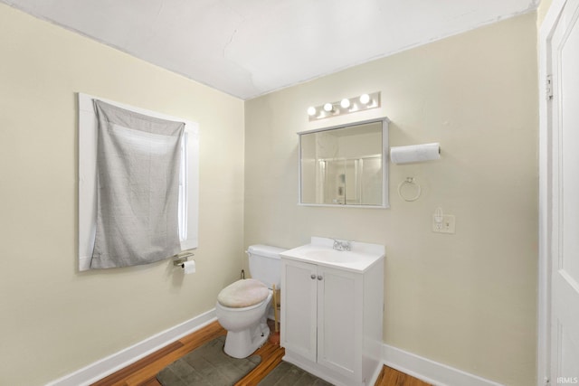 full bath featuring wood finished floors, baseboards, and toilet