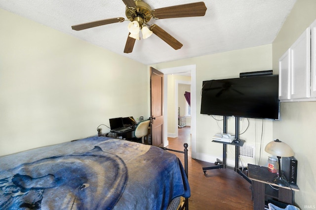 bedroom with wood finished floors, a textured ceiling, a ceiling fan, and baseboards