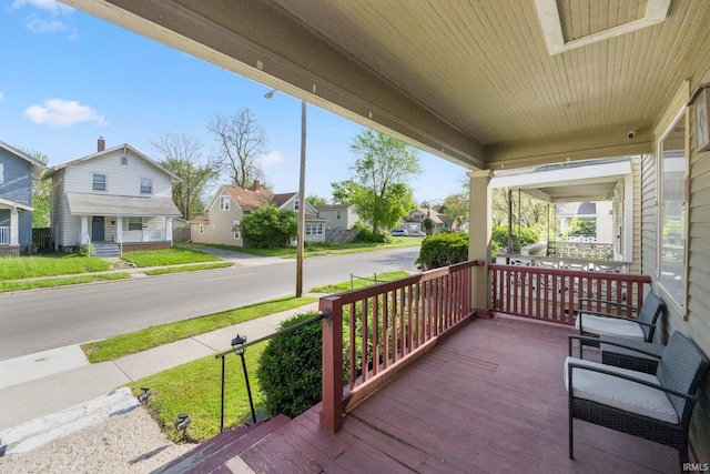 wooden terrace featuring a porch and a residential view