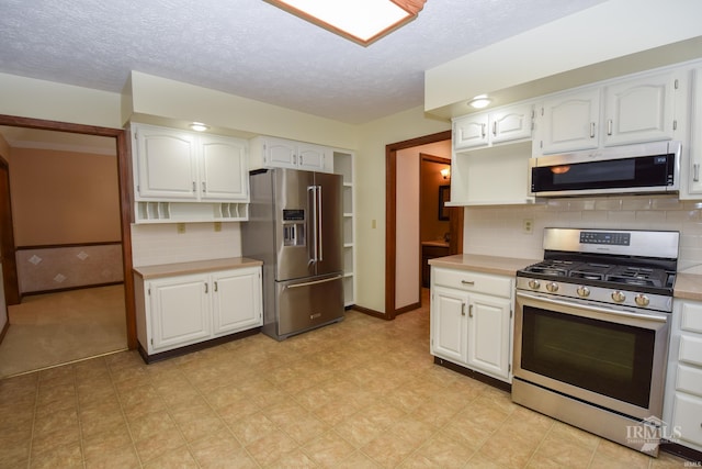 4105 W Friar Dr, Muncie, IN 47304 - kitchen with appliances with stainless steel finishes, light countertops, white cabinetry, baseboards, and a textured ceiling